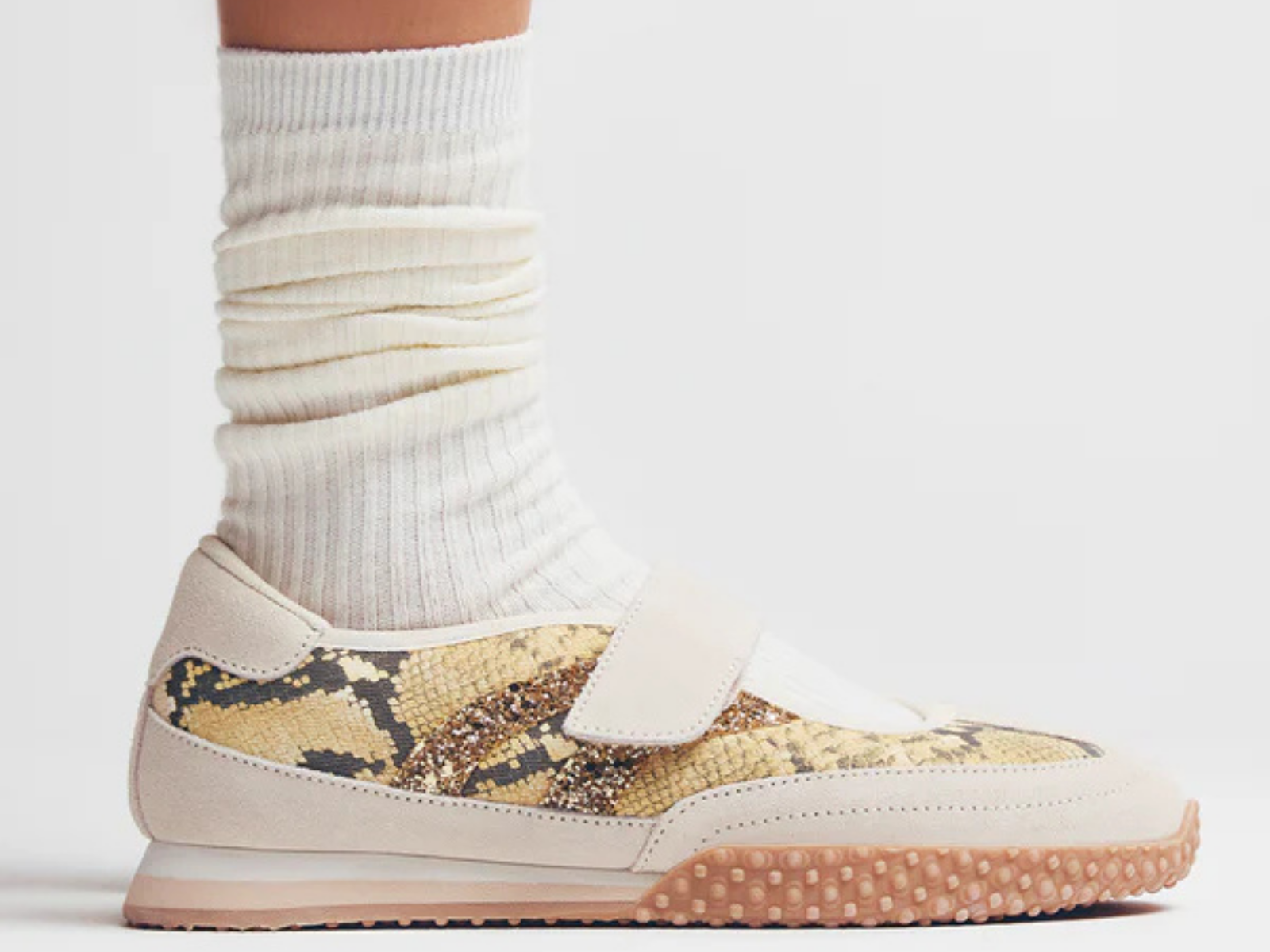 Ténis com padrão animal print e sola castanha, usado com meias brancas caneladas