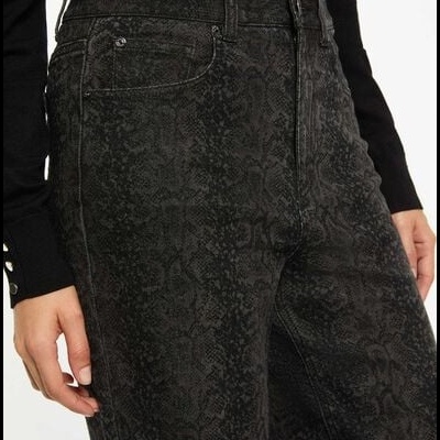 Calças pretas com padrão de pele de cobra e camisa preta de manga comprida