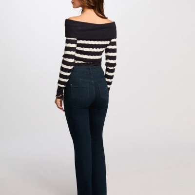 Mulher de costas com camisola às riscas e calças de ganga azul escuro