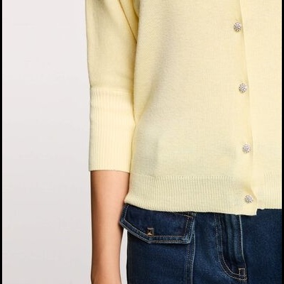 Cardigã amarelo claro com botões decorativos e calças de ganga azul escuro