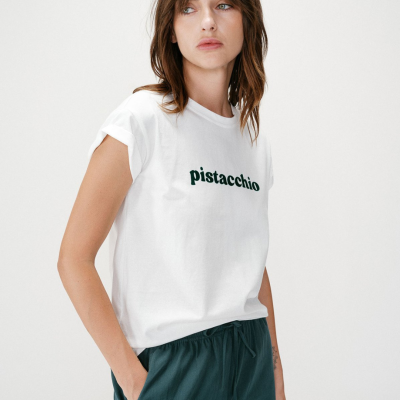 T-shirt branca com texto pistacchio e calças verdes escuras