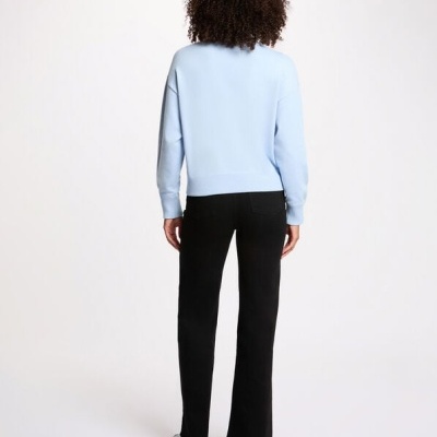 Mulher vista de costas com camisola azul clara e calças pretas