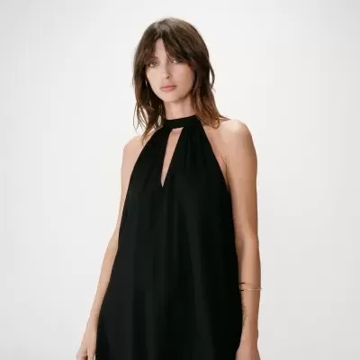 Vestido preto de gola alta com abertura em V, usado por mulher