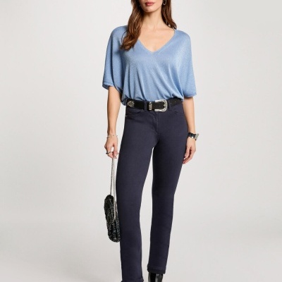 Mulher com camisola azul clara, calças pretas e sapatos de salto alto