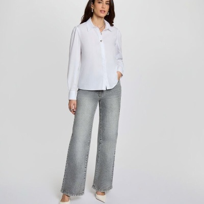 Mulher com camisa branca, calças de ganga cinza largas e sapatos brancos de salto