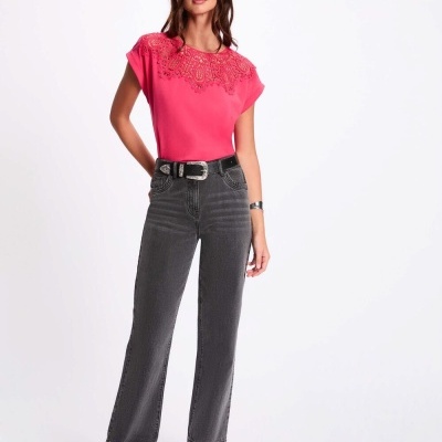 Mulher com camisola rosa e calças de ganga cinzentas num fundo branco