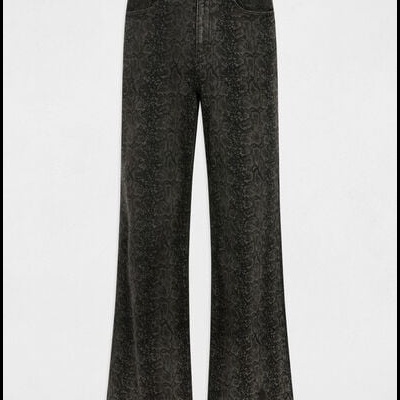 Calças pretas largas com padrão pele de cobra e etiqueta branca com texto