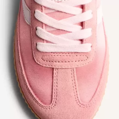 Vista superior de ténis desportivo cor-de-rosa com atacadores brancos.