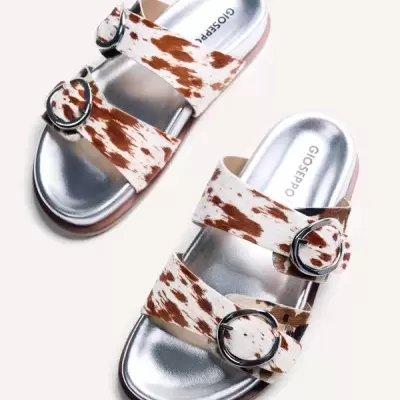 Sandálias com padrão animal castanho e branco com fivelas prateadas e interior prateado