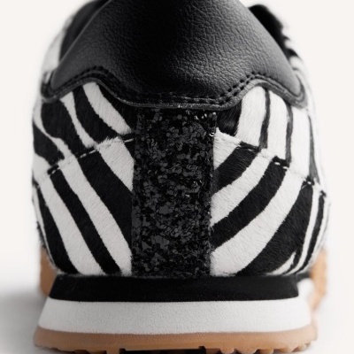 Sapatilha com padrão de zebra preto e branco visto da parte de trás