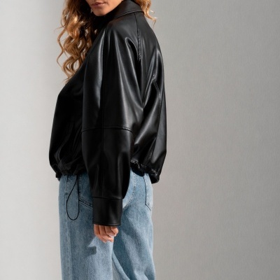 Casaco preto sintético com calças largas de ganga azul clara