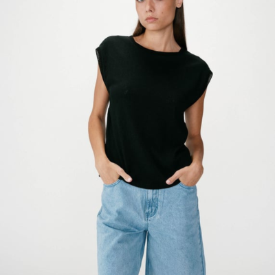 Mulher com t-shirt preta sem mangas e calções de ganga claros