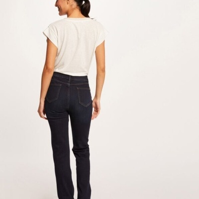 Mulher de costas com top branco e jeans escuros