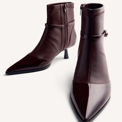 Botins de couro castanho escuro com salto fino e bico pontiagudo.