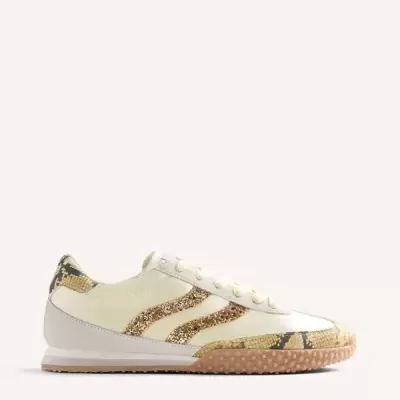 Sapatilha desportiva creme com detalhes em padrão cobra e riscas douradas