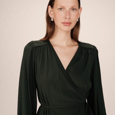 Mulher com vestido preto de manga comprida e decote em V