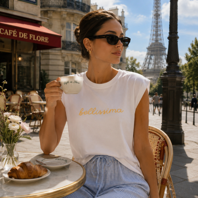 Mulher com t-shirt branca bellissima e calças azuis numa esplanada em Paris com chávena Café de Flore.