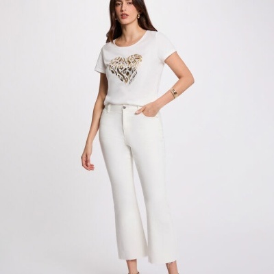 Mulher vestindo t-shirt branca com estampa dourada e calças brancas de jeans