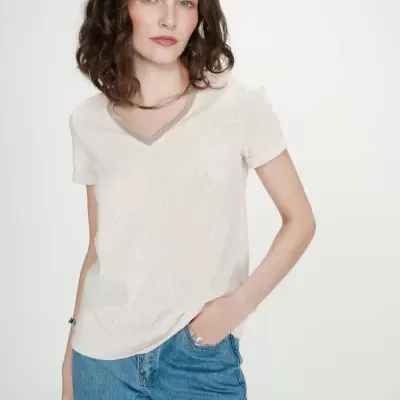 Mulher com t-shirt creme e calças de ganga azuis