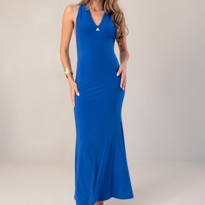 Vestido comprido azul com decote em V e detalhe metálico, mulher com sandálias douradas, fundo neutro