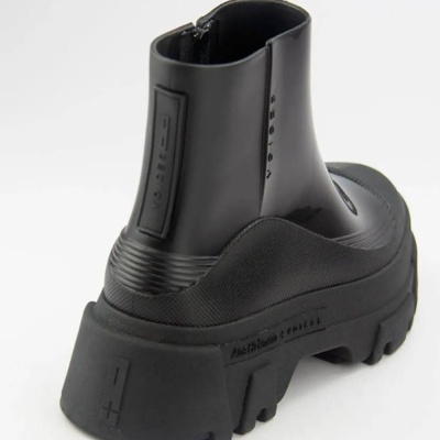 Botim preto de sola grossa e corpo em couro e tecido, vista traseira