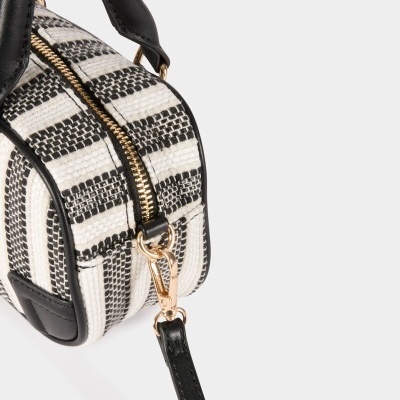 Mala pequena preta e branca com padrão aos quadrados e fecho dourado