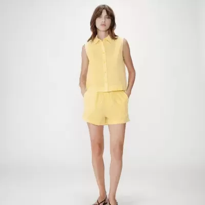 Conjunto amarelo de camisa sem mangas e calções com padrão xadrez pequeno.