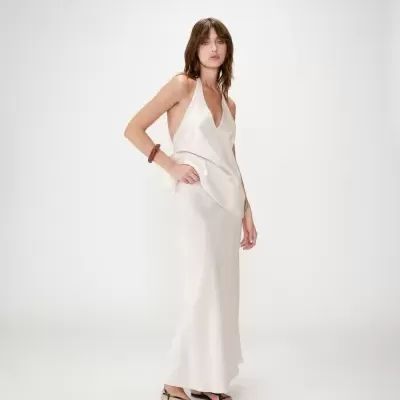 Mulher a usar vestido longo creme acetinado e sandálias pretas