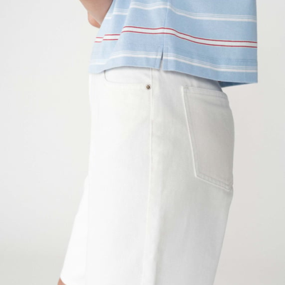 Calças brancas e t-shirt azul com riscas vermelhas e brancas.