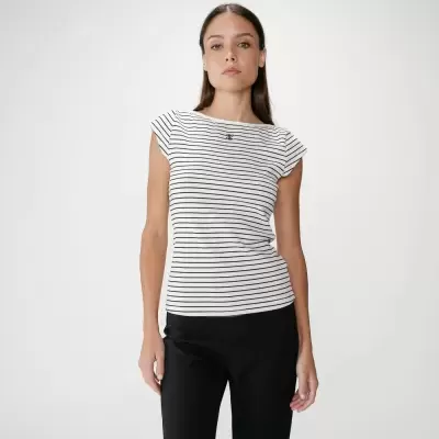 Mulher com t-shirt de riscas pretas e brancas e calças pretas num fundo branco