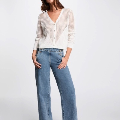 Mulher com camisola branca de malha e calças de ganga azuis