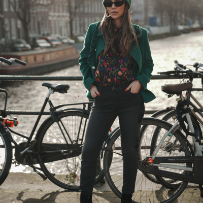 Mulher com roupas de inverno elegantes junto a bicicletas num canal urbano