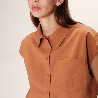 Camisa castanha de algodão com bolso e botões ao centro, gola tradicional, mangas curtas