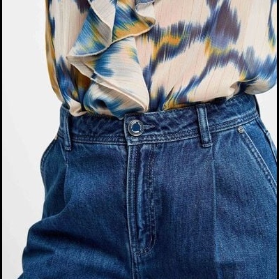 Calças de ganga azul escuro e blusa estampada com folhos