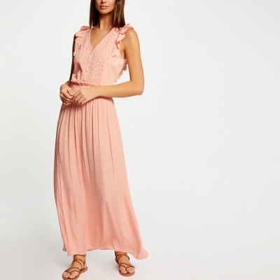 Vestido longo cor de rosa claro com renda e folhos, usado por mulher
