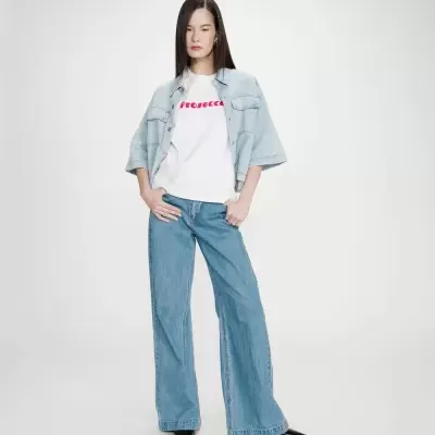 Mulher com t-shirt branca Prosecco, camisa e calças de ganga e sapatos pretos