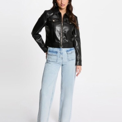 Mulher vestindo casaco preto de pele sintética e calças de ganga azuis claras.