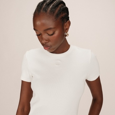 Camiseta branca de manga curta ajustada usada por modelo com cabelo trançado