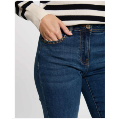 Calças de ganga azuis com camisola branca de riscas pretas.