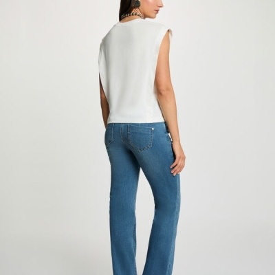 Mulher de costas com camisola branca sem mangas e calças de ganga azuis