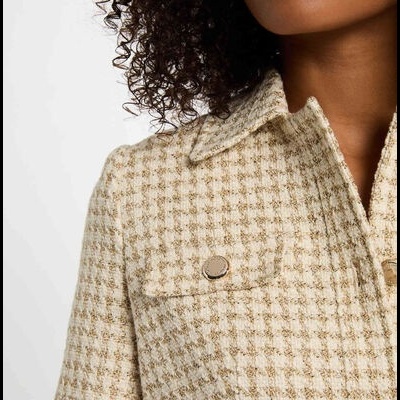 Casaco bege com padrão xadrez e botões metálicos detalhado no ombro