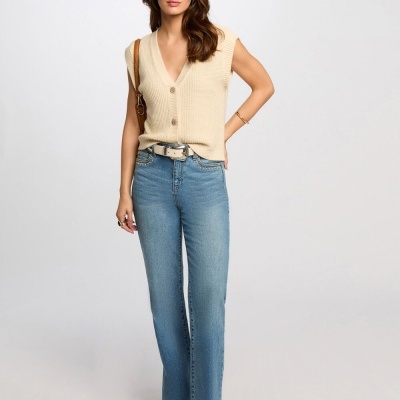 Mulher com camisola bege sem mangas e jeans azuis claros