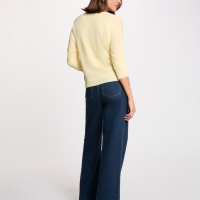 Mulher de costas com camisola amarela e calças de ganga azul escuras