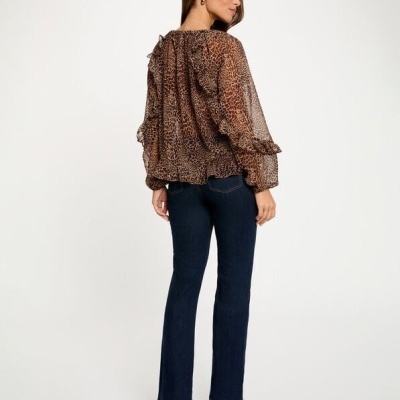 Blusa feminina animal print castanha com mangas longas e jeans escuros vista de costas