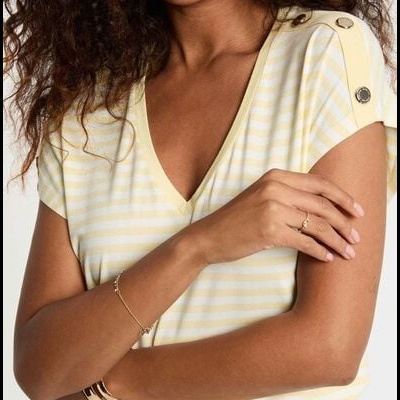 T-shirt feminina às riscas amarelas e brancas com botões metálicos no ombro.