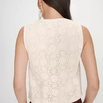 Top renda bege circular e calças castanhas vistas de costas.