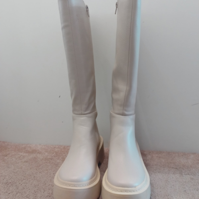 Botas altas brancas de couro com sola plataforma bege em piso de carpete claro