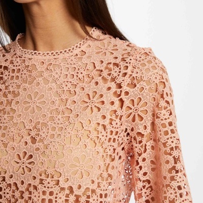Camisola de mulher em renda rosa com padrão floral e detalhes recortados
