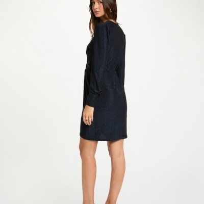 Vestido preto de manga comprida com textura usado por mulher