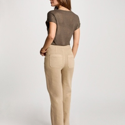 Mulher de costas com t-shirt castanha e calças bege com bolsos